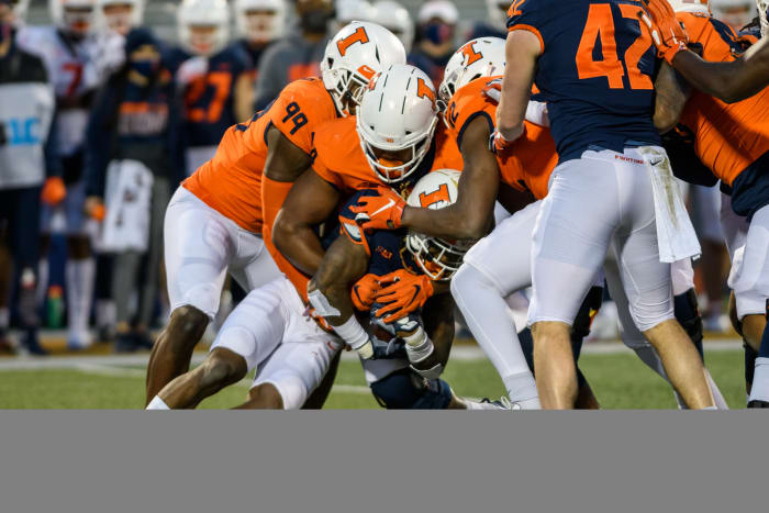 Illinois outside linebacker Owen Carney Jr. (99) and defensive end Jer’Zhan Newton (94) combine for a tackle during the 2021 spring game on April 19, 2021.